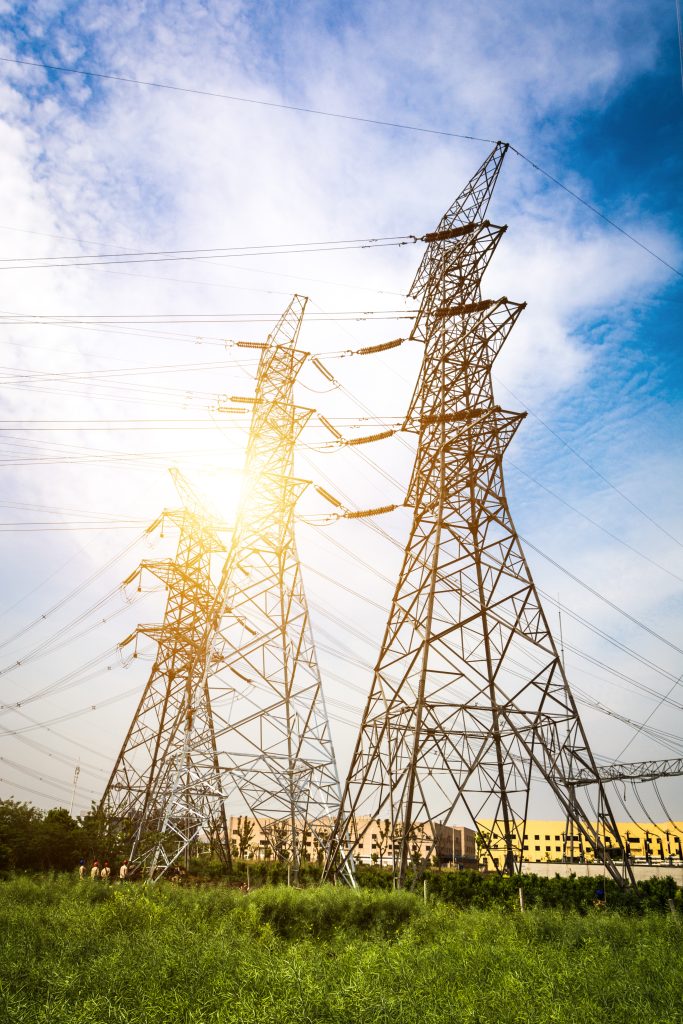 Sun setting behind the silhouette of electricity pylons